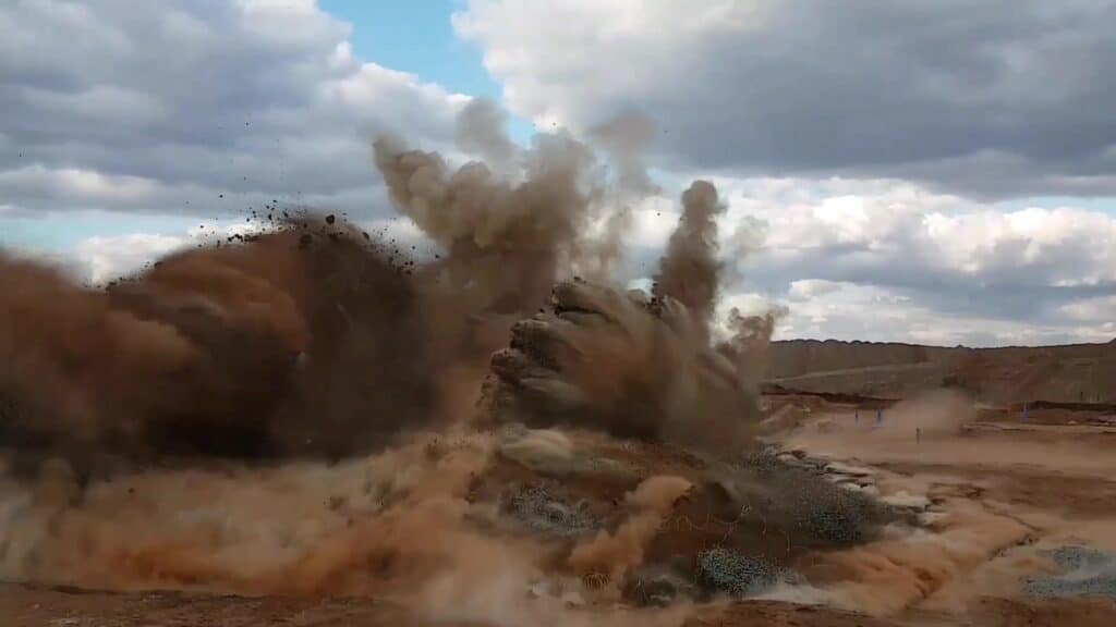 A controlled explosion, capturing the moment when the blast is dispersing earth and debris into the air.