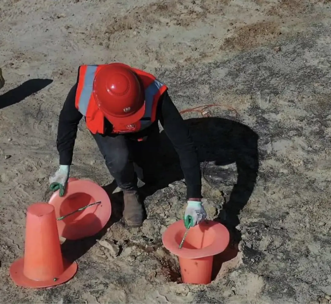 Pink Collar Saver Cone being placed in a blast hole