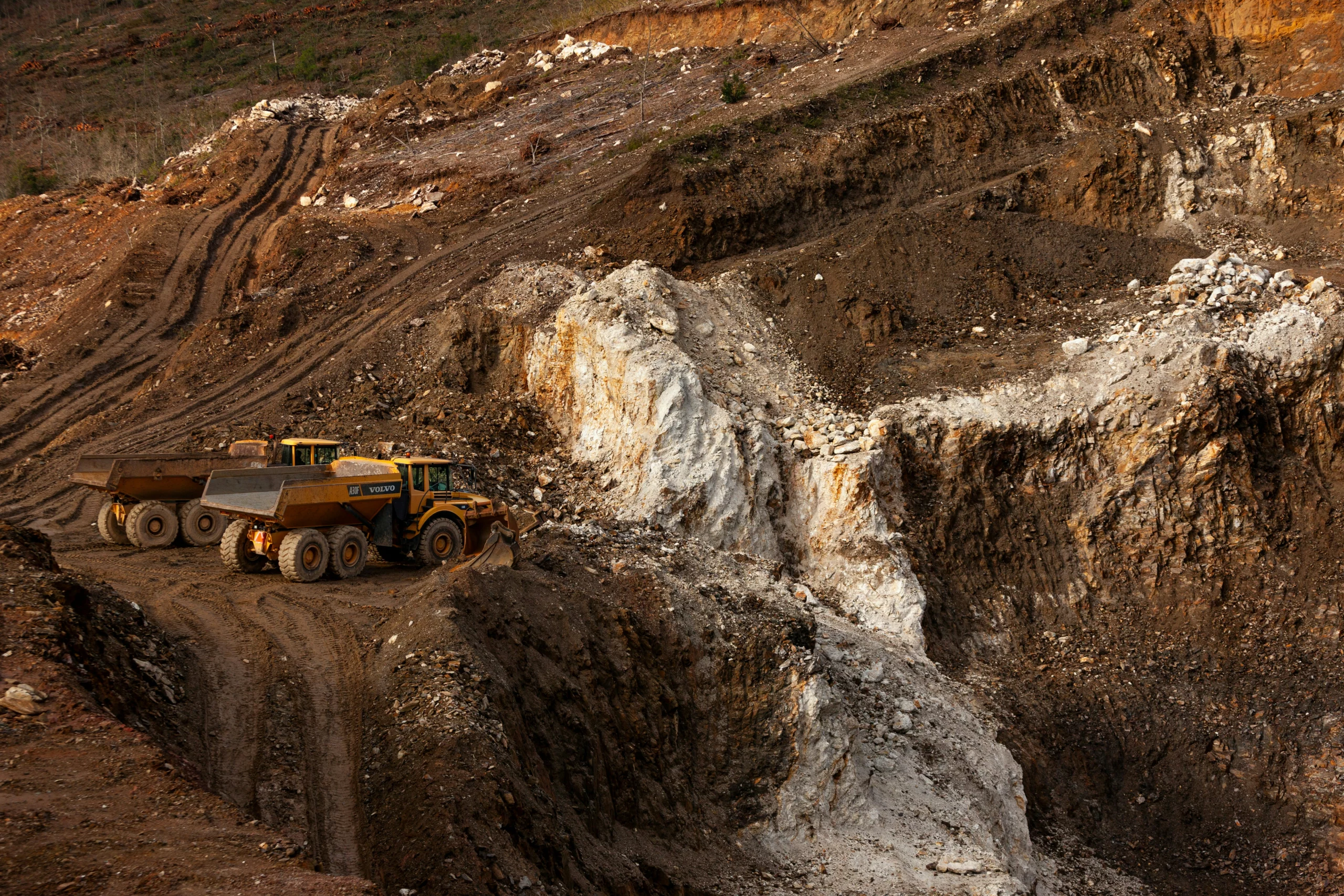 A dump truck hauling blasted rock illustrating Varistem and HelixPlug stemming applications.